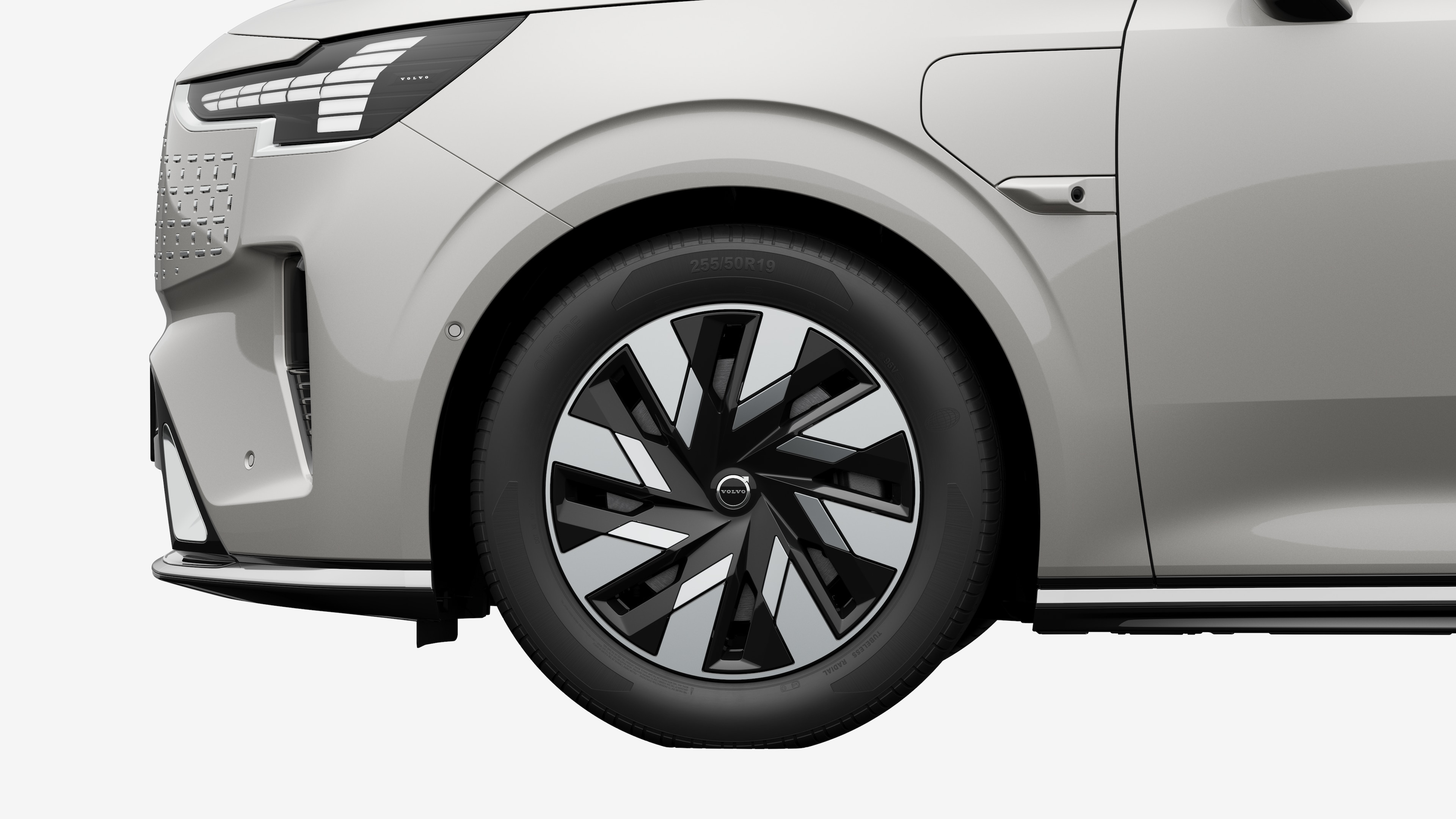 沃尔沃汽车外部侧视图聚焦于前轮和挡泥板，背景为朴素的工作室背景。