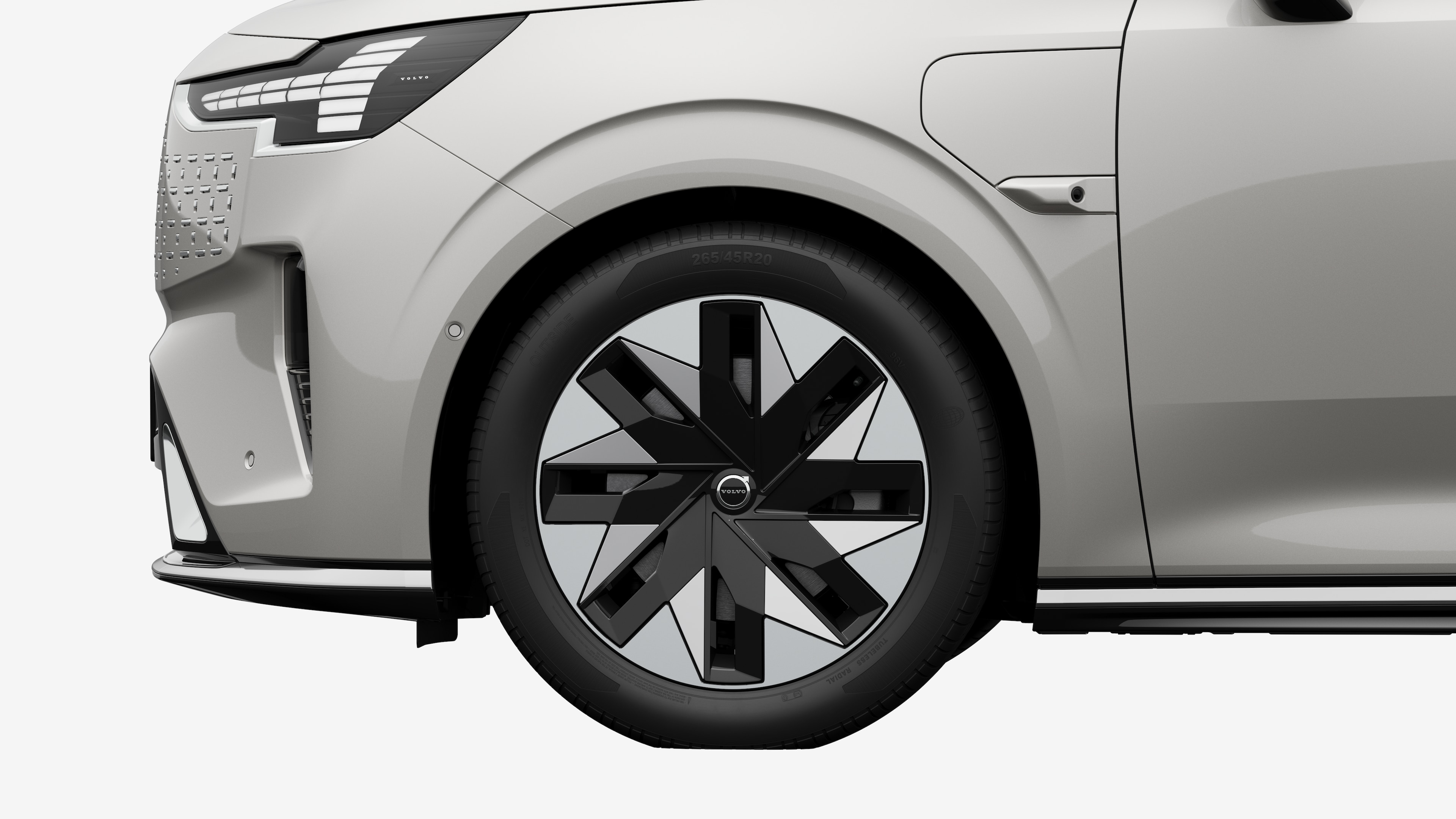 沃尔沃汽车外部侧视图聚焦于前轮和挡泥板，背景为朴素的工作室背景。