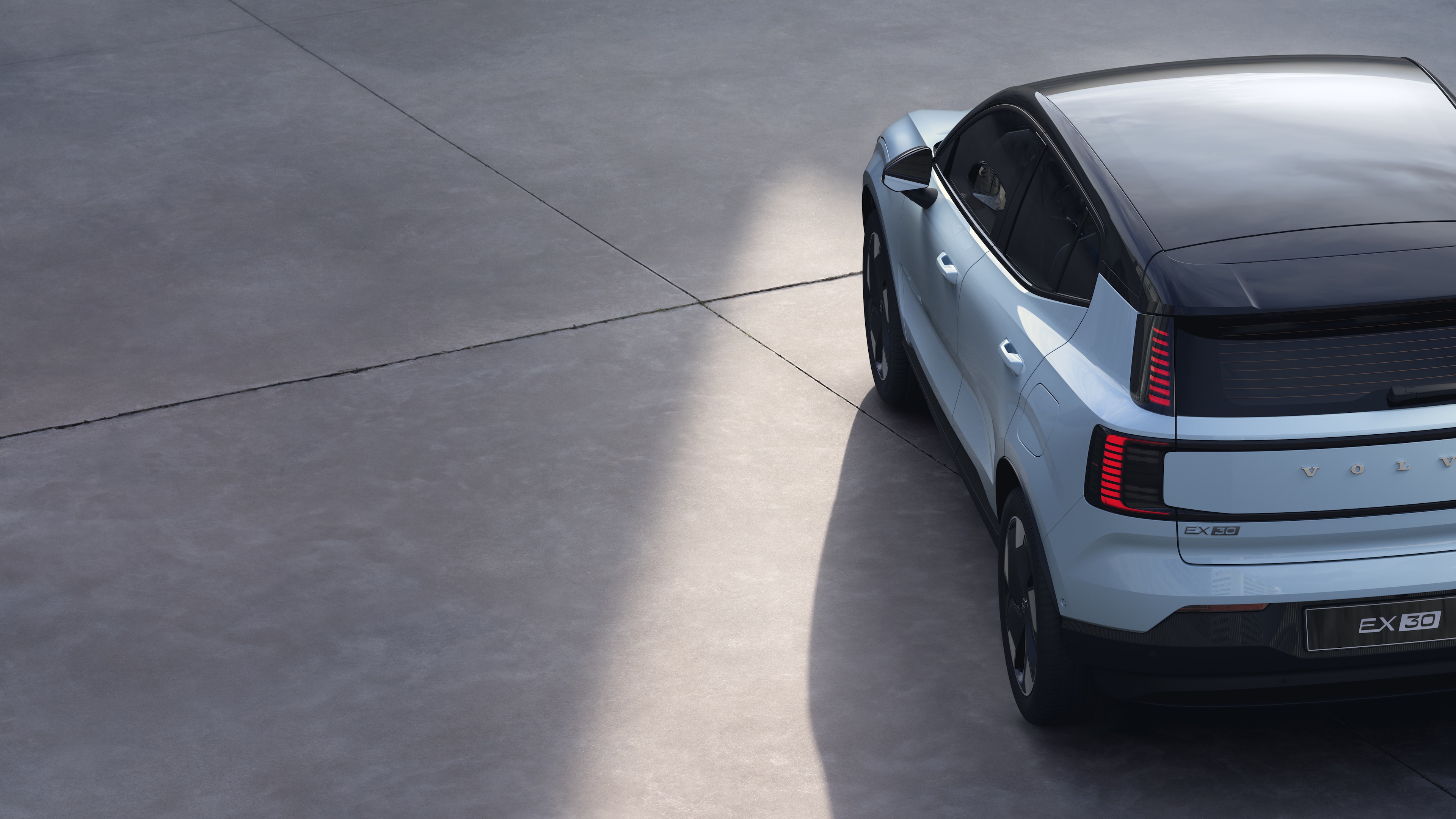 沃尔沃汽车四分之三后视图在纯工作室背景上，展示了尾灯设计和后窗结构，用于外部细节。