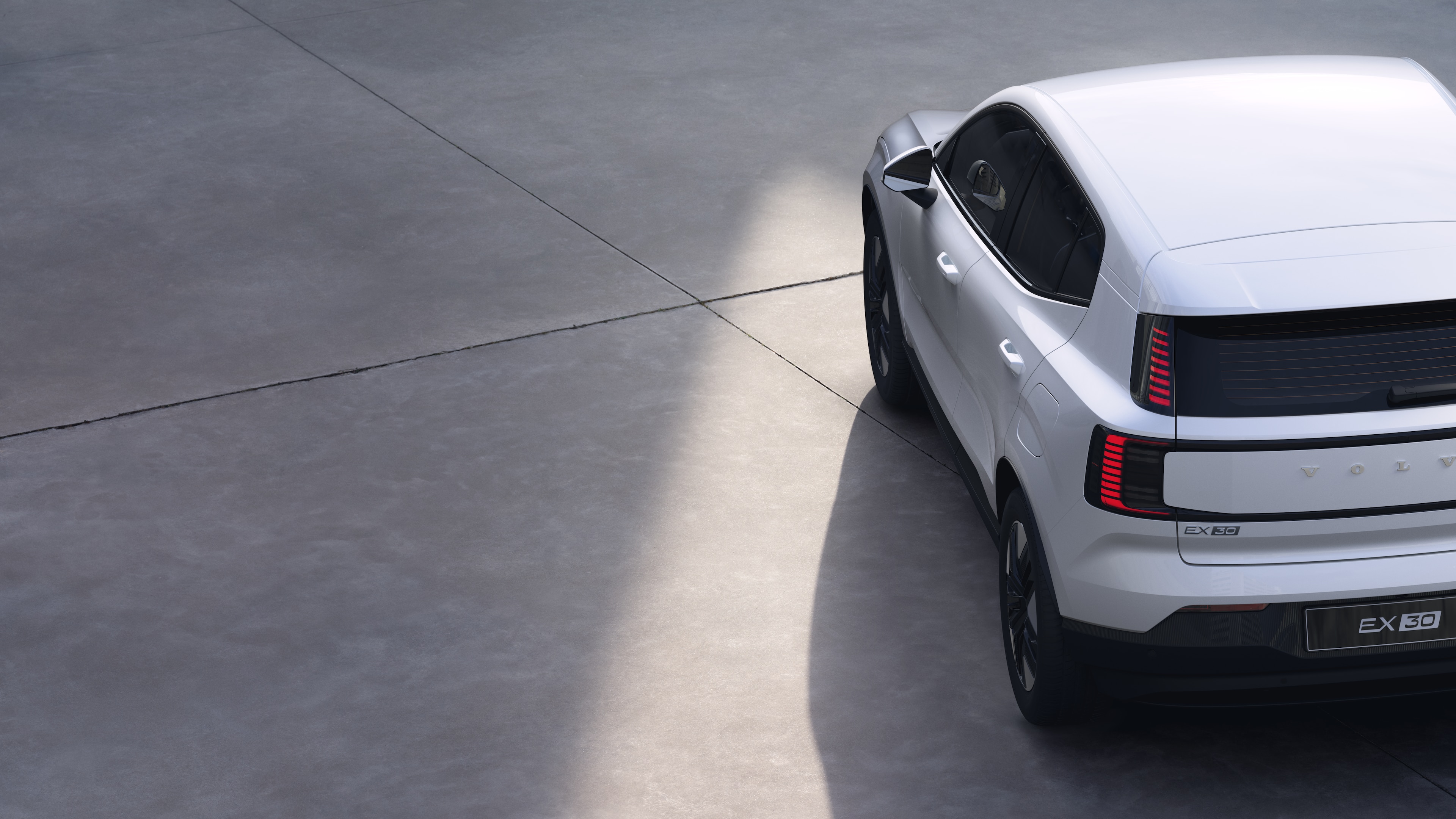 沃尔沃汽车四分之三后视图在纯工作室背景上，展示了尾灯设计和后窗结构，用于外部细节。