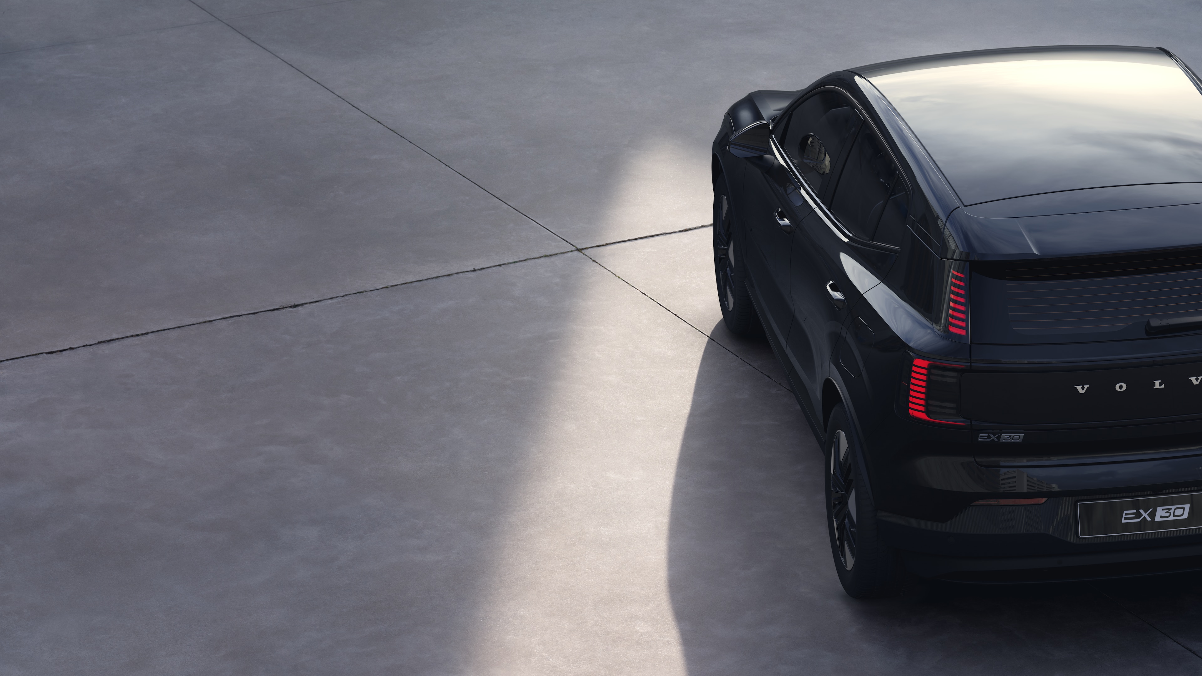 沃尔沃汽车四分之三后视图在纯工作室背景上，展示了尾灯设计和后窗结构，用于外部细节。