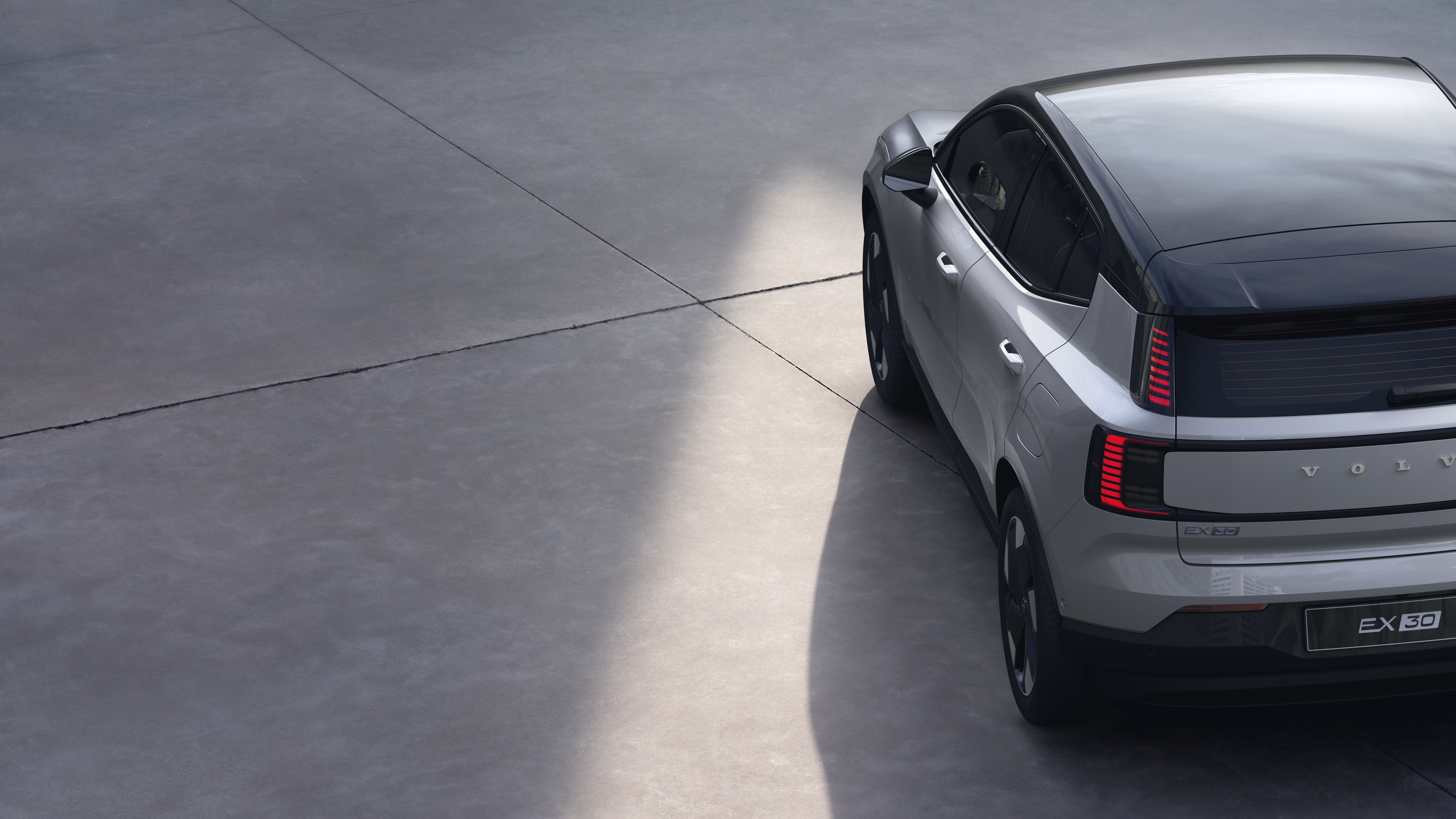 沃尔沃汽车四分之三后视图在纯工作室背景上，展示了尾灯设计和后窗结构，用于外部细节。