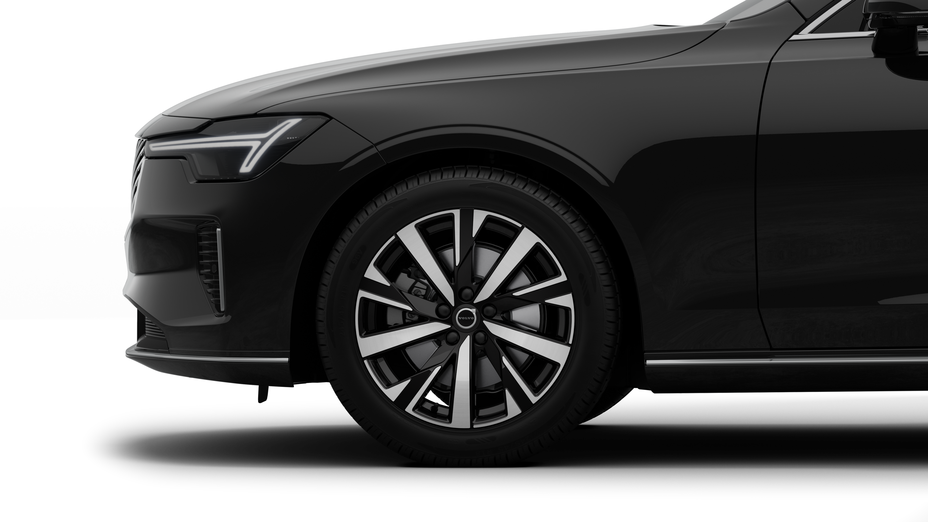 沃尔沃汽车外部侧视图聚焦于前轮和挡泥板，背景为朴素的工作室背景。