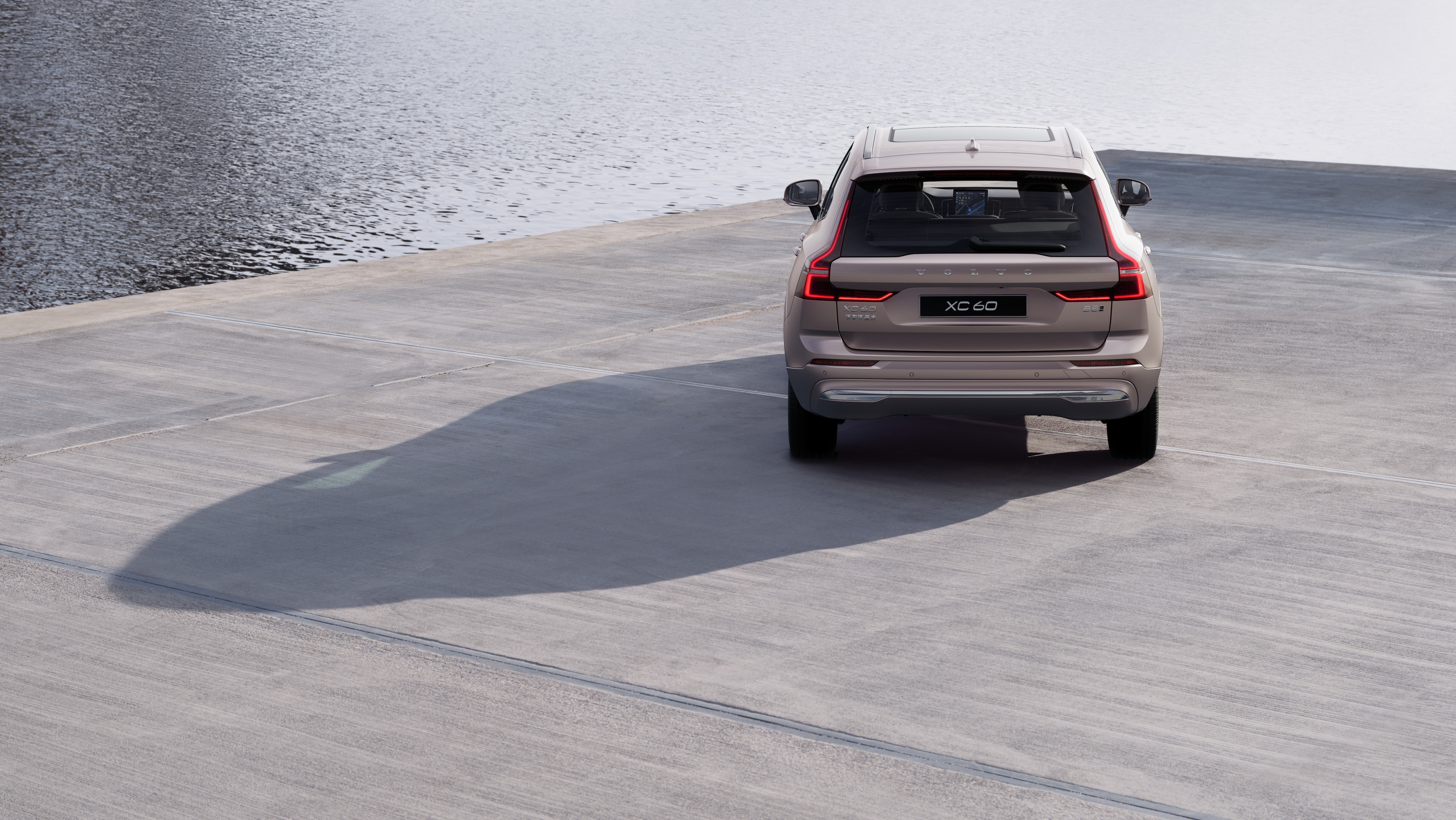 沃尔沃汽车后视图在蜿蜒的沿海道路上,以海滨为背景。