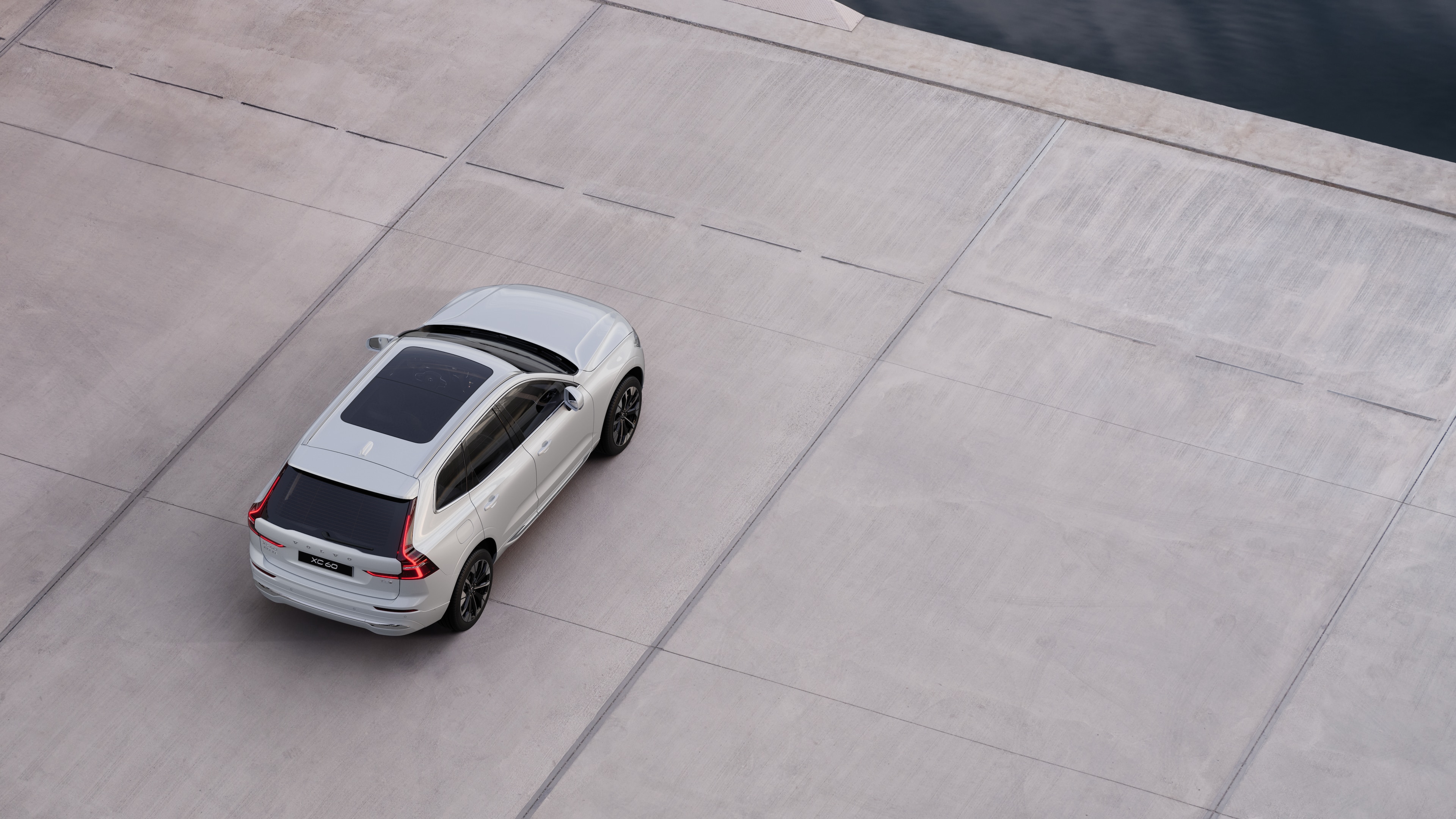 沃尔沃汽车后视图停在安静的水边街道上,以铺好的走道和水为背景。