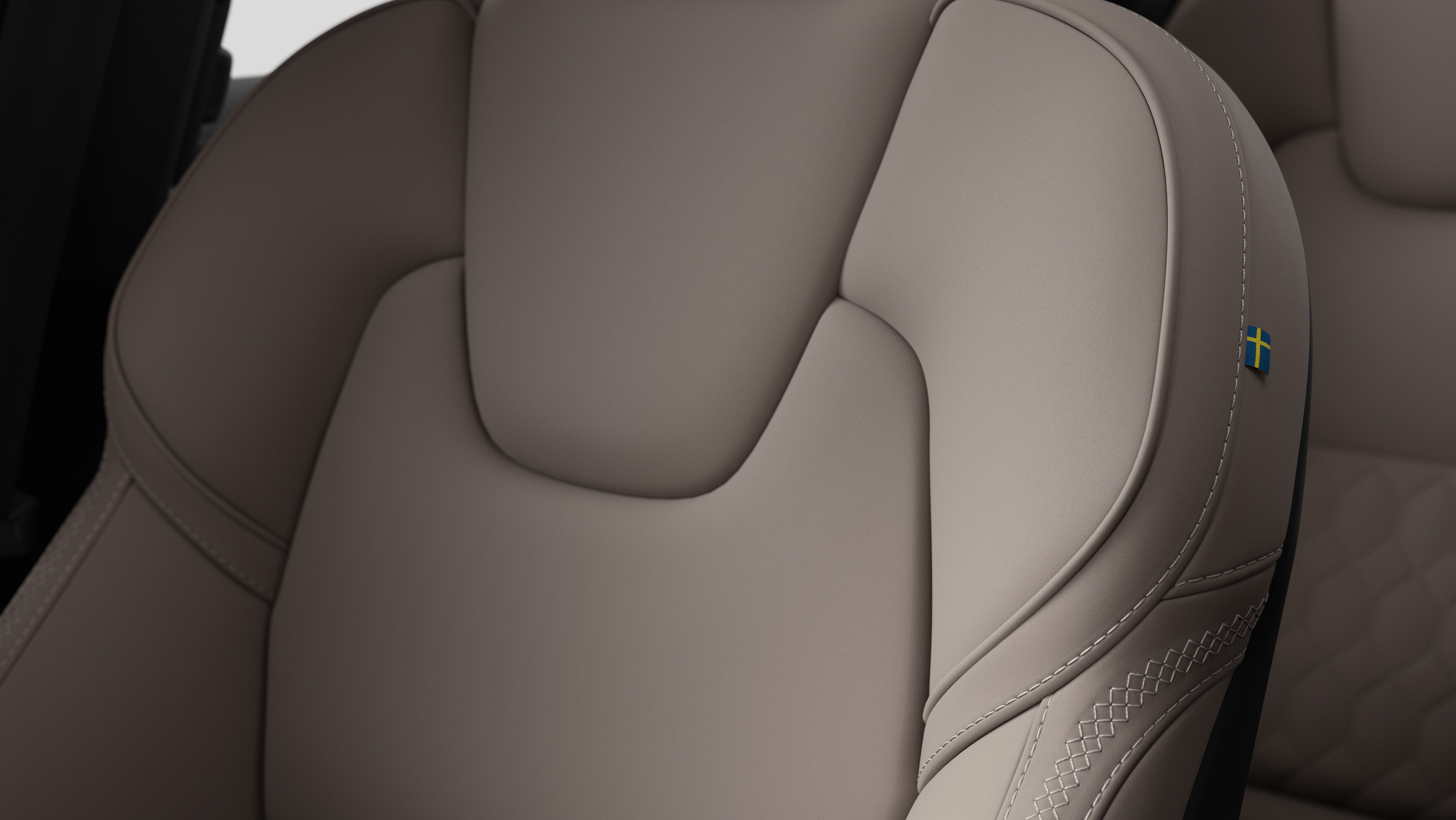 沃尔沃汽车内部座椅细节的特写，显示缝线和瑞典小旗牌。