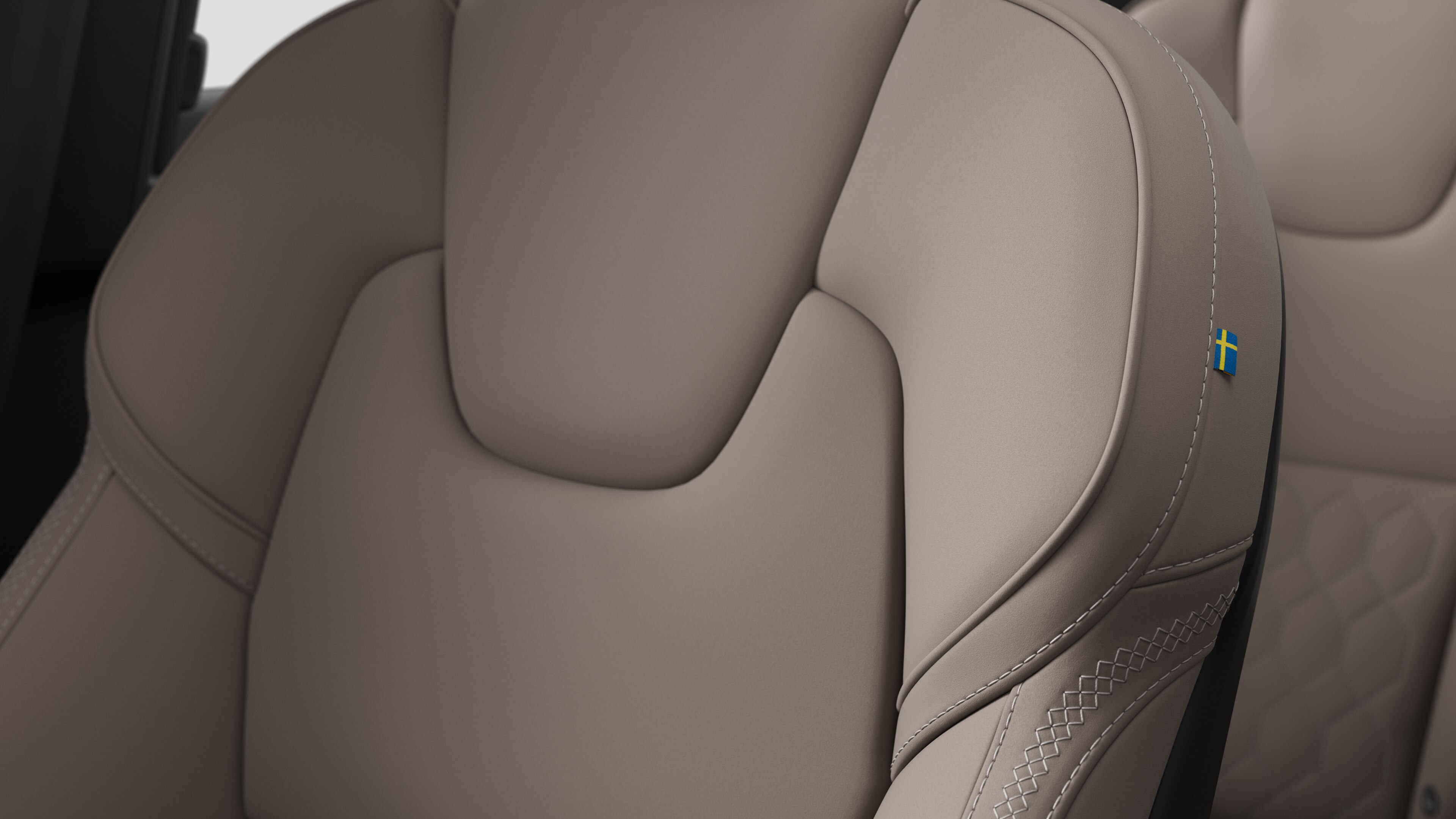 沃尔沃汽车内部座椅细节的特写，显示缝线和瑞典小旗牌。