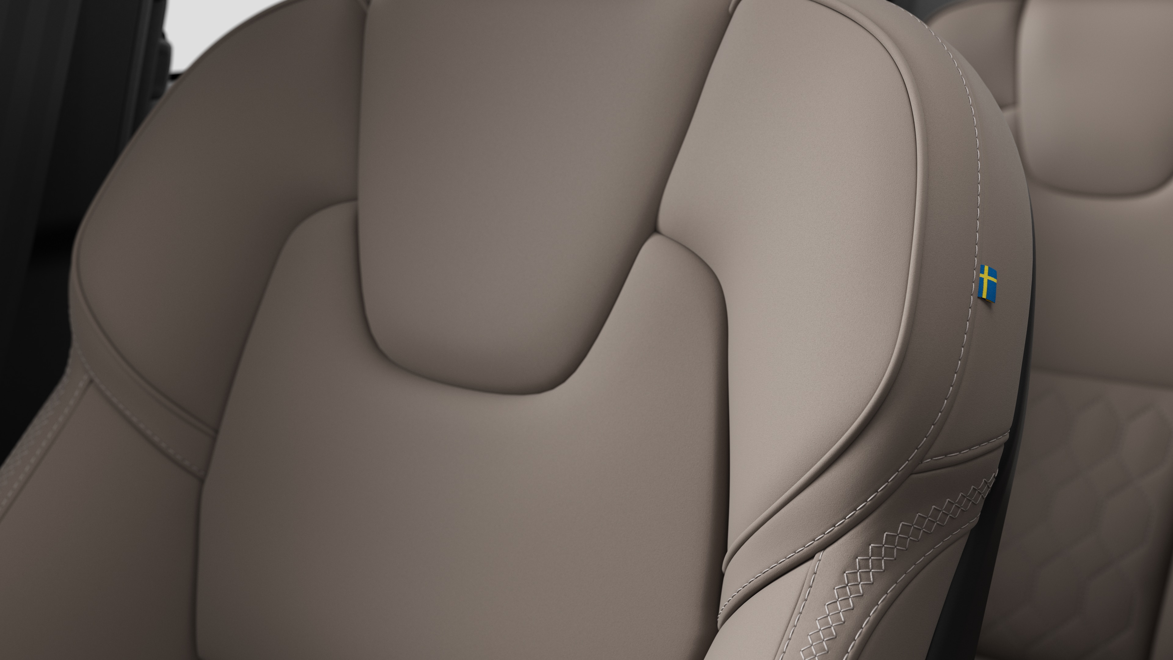 沃尔沃汽车内部座椅细节的特写，显示缝线和瑞典小旗牌。