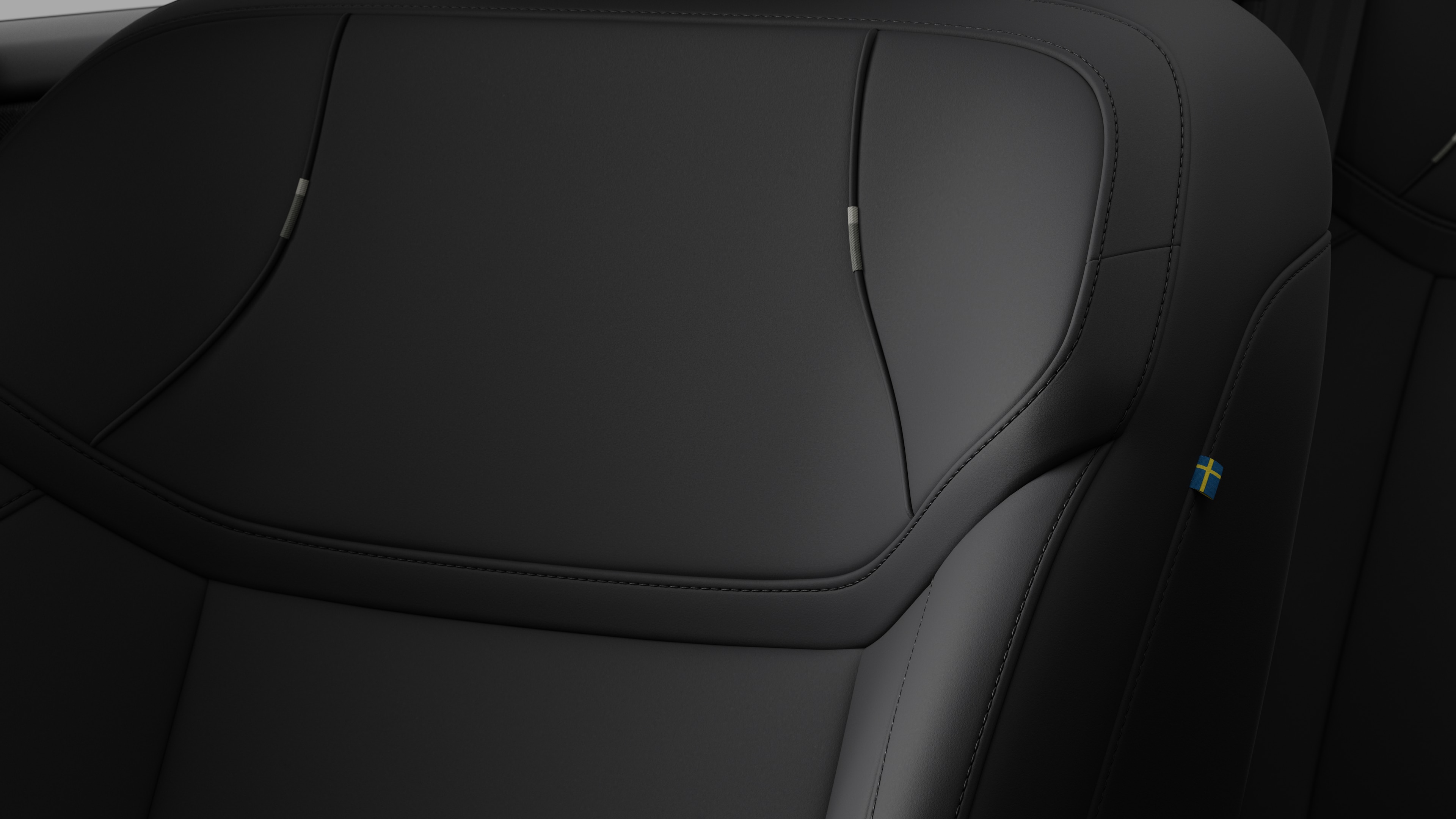 沃尔沃汽车内部座椅细节的特写，显示缝线和瑞典小旗牌。