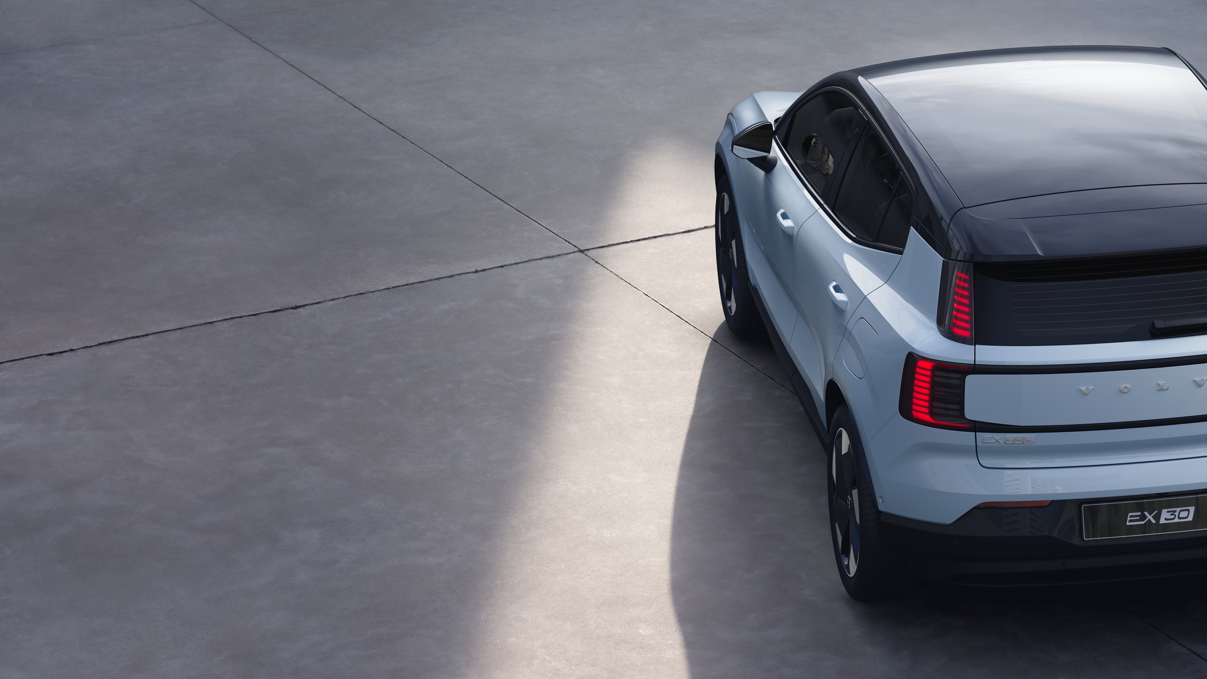 沃尔沃汽车四分之三后视图在纯工作室背景上，展示了尾灯设计和后窗结构，用于外部细节。