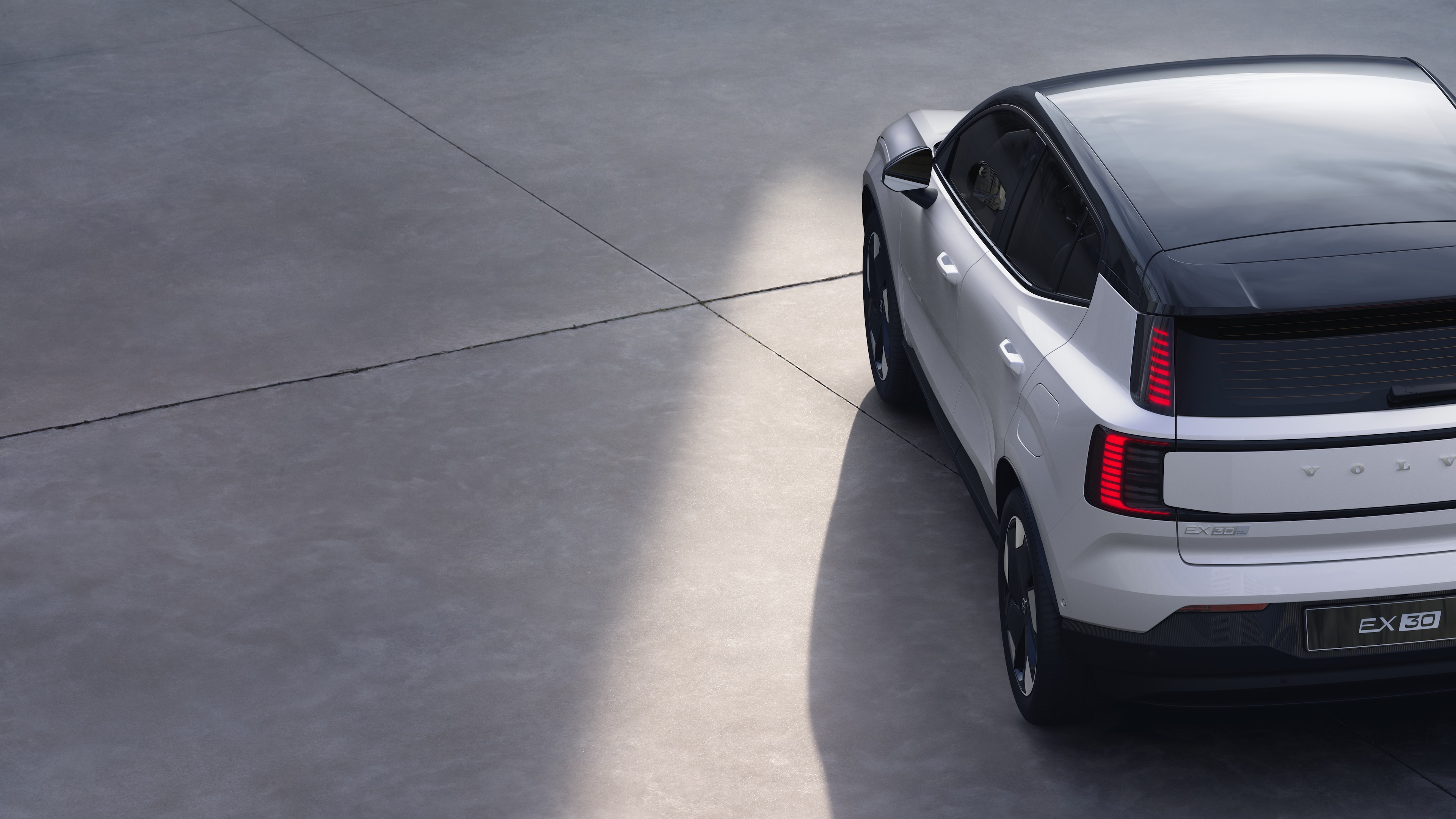 沃尔沃汽车四分之三后视图在纯工作室背景上，展示了尾灯设计和后窗结构，用于外部细节。