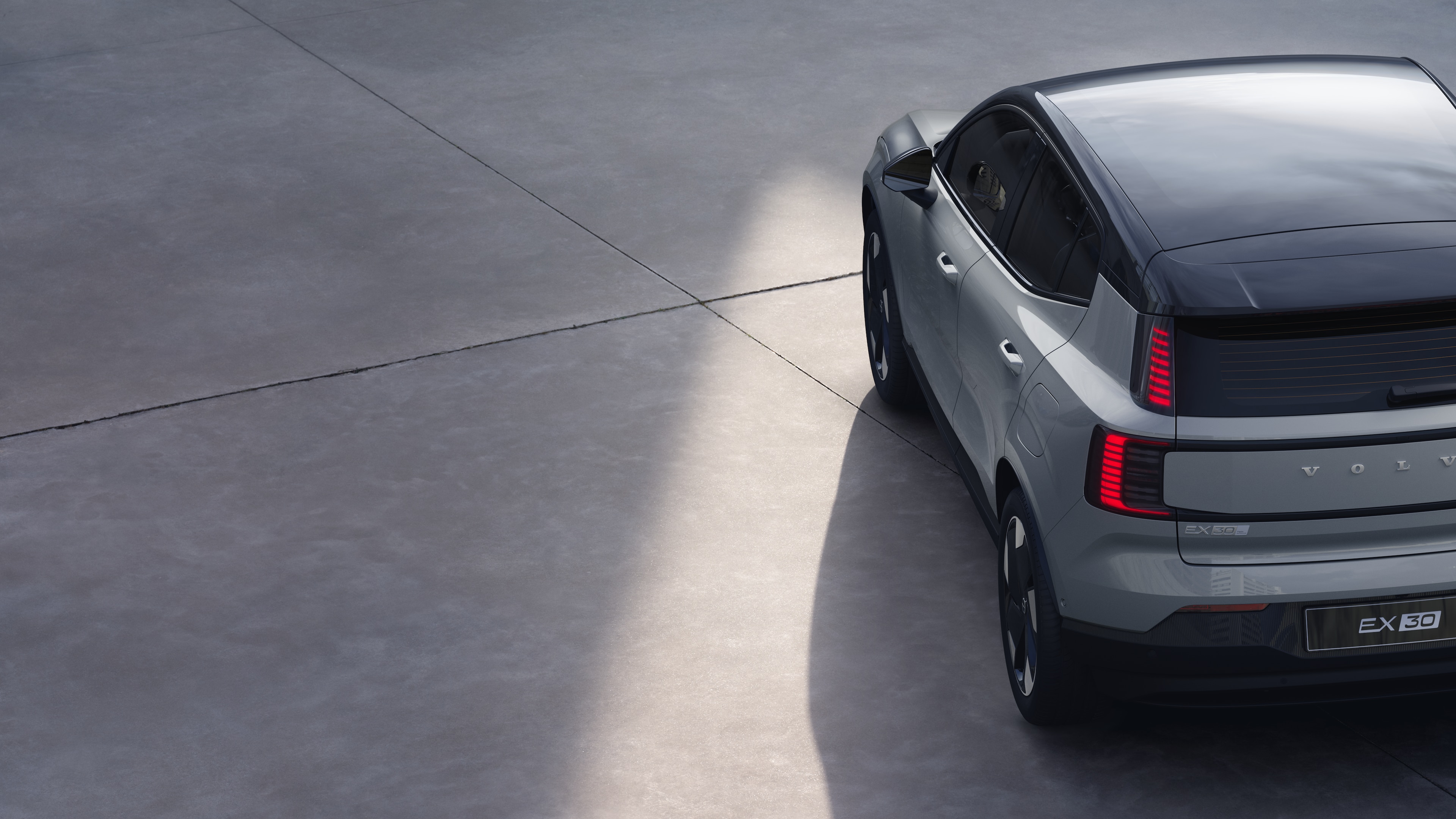 沃尔沃汽车四分之三后视图在纯工作室背景上，展示了尾灯设计和后窗结构，用于外部细节。