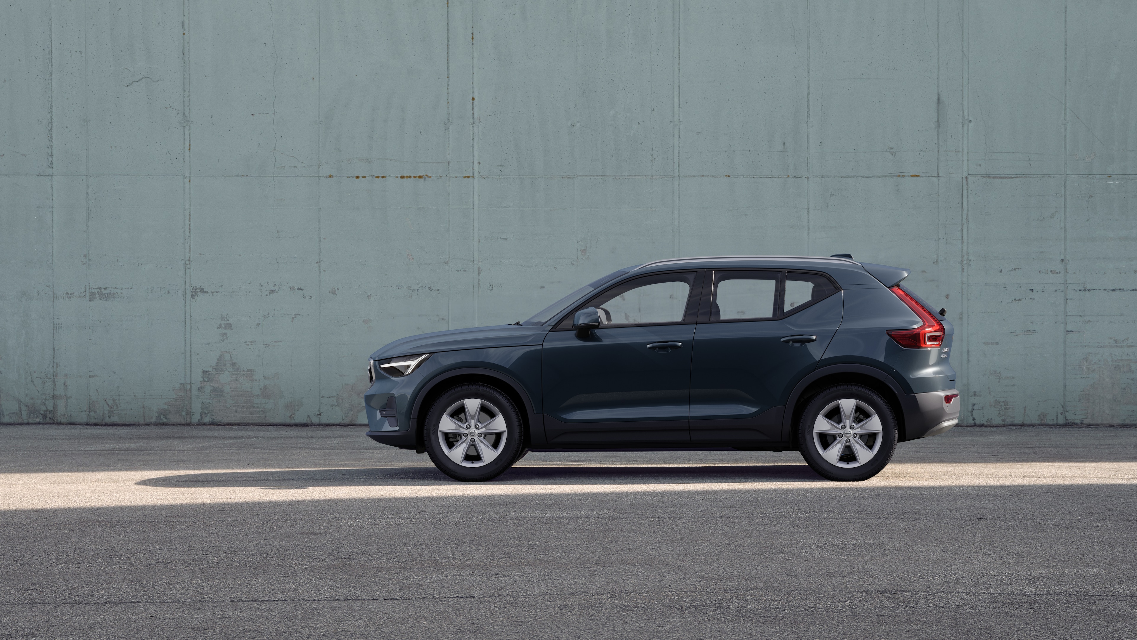 沃尔沃汽车，侧视图，停在朴素的混凝土墙背景上。