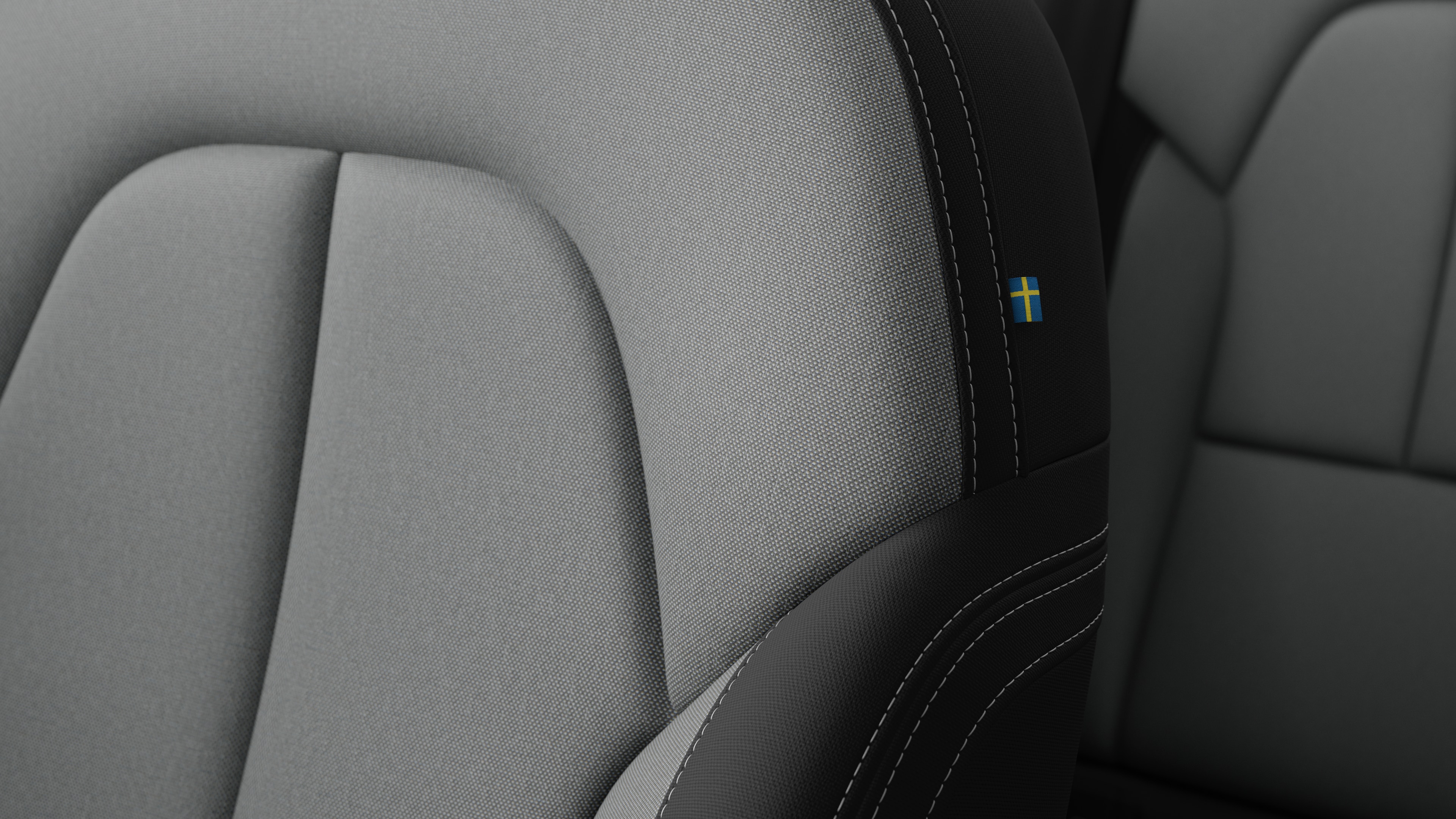 沃尔沃汽车内部座椅细节的特写，显示缝线和瑞典小旗牌。