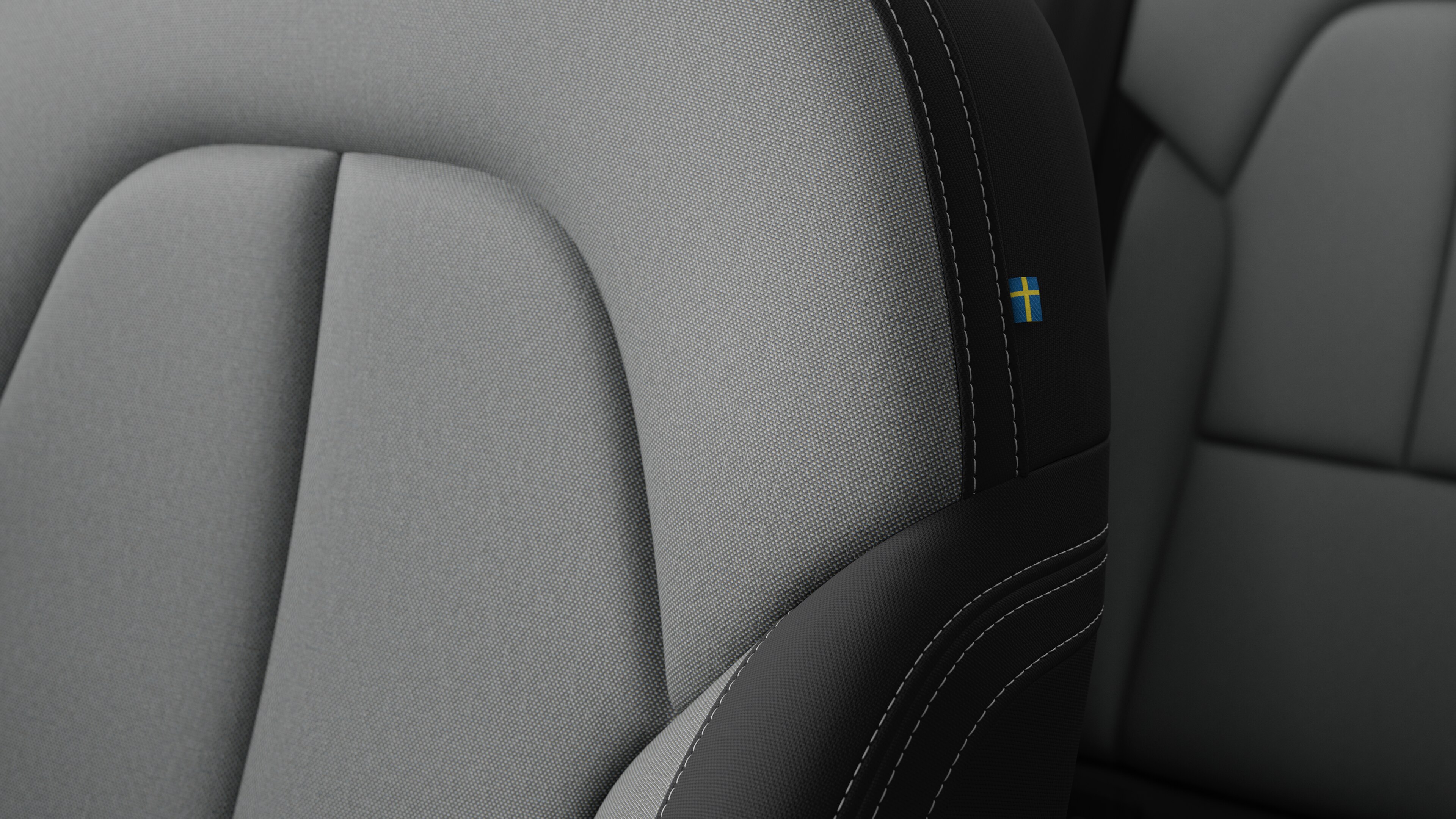 沃尔沃汽车内部座椅细节的特写，显示缝线和瑞典小旗牌。